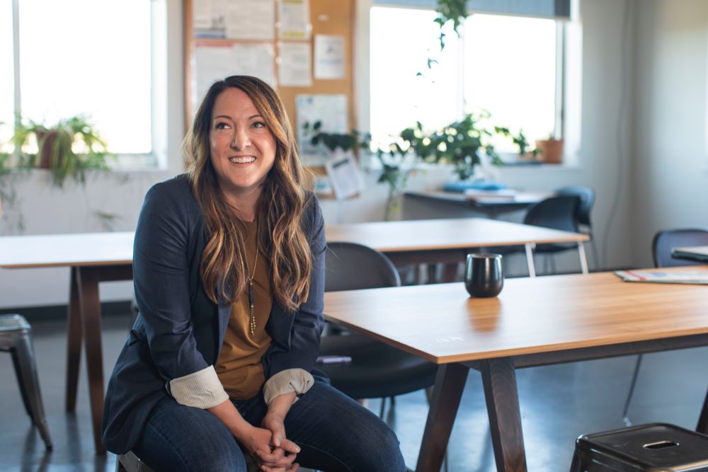 Professional woman sitting at a conference table with a cup of coffee