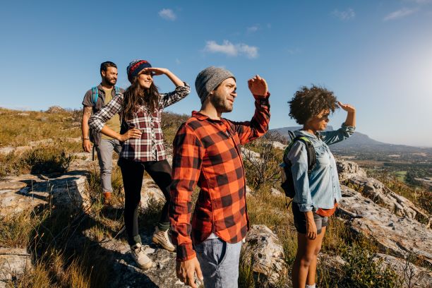 four people on a hillside looking into the distance