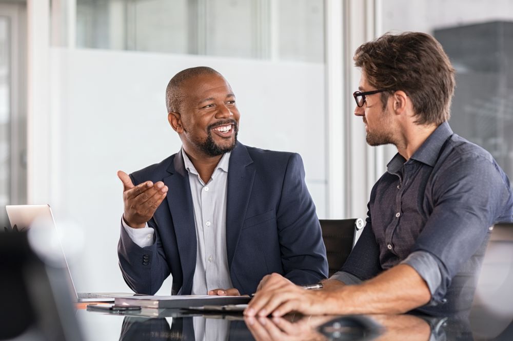 two men sitting together at a table