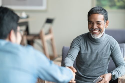 men shaking hands over a table