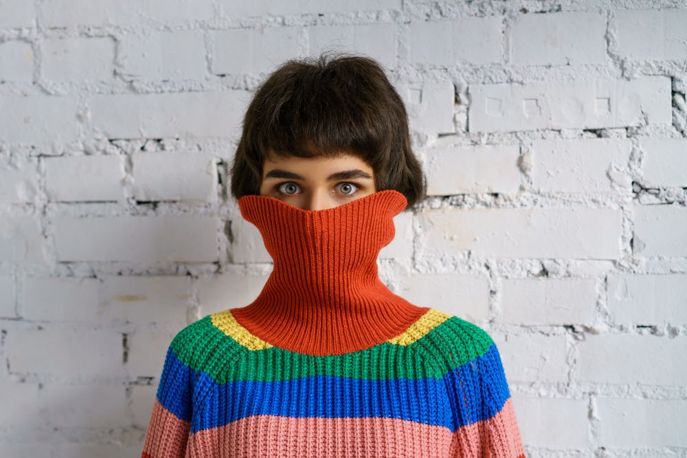 Woman hiding face in her sweater