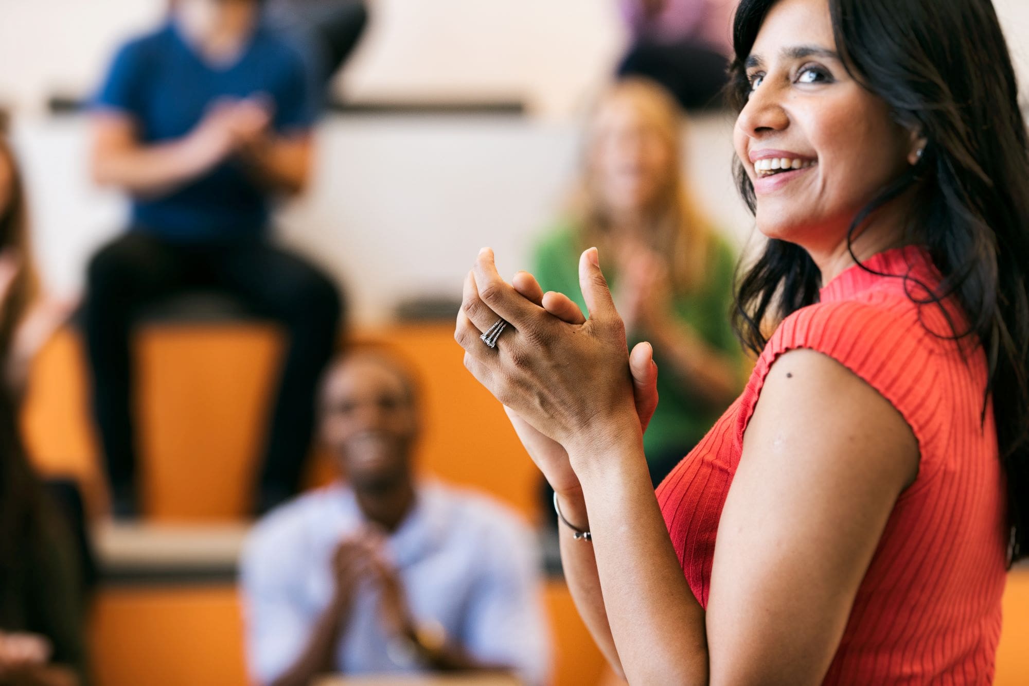 woman giving a presentation, looking up and clapping
