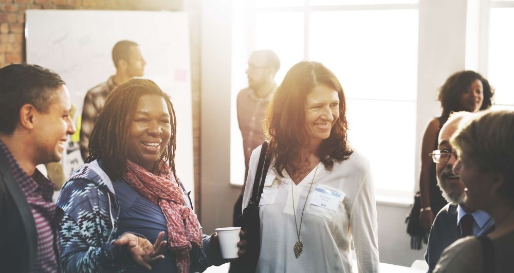 Employee health and wellbeing- image of people gathered in a conference room talking